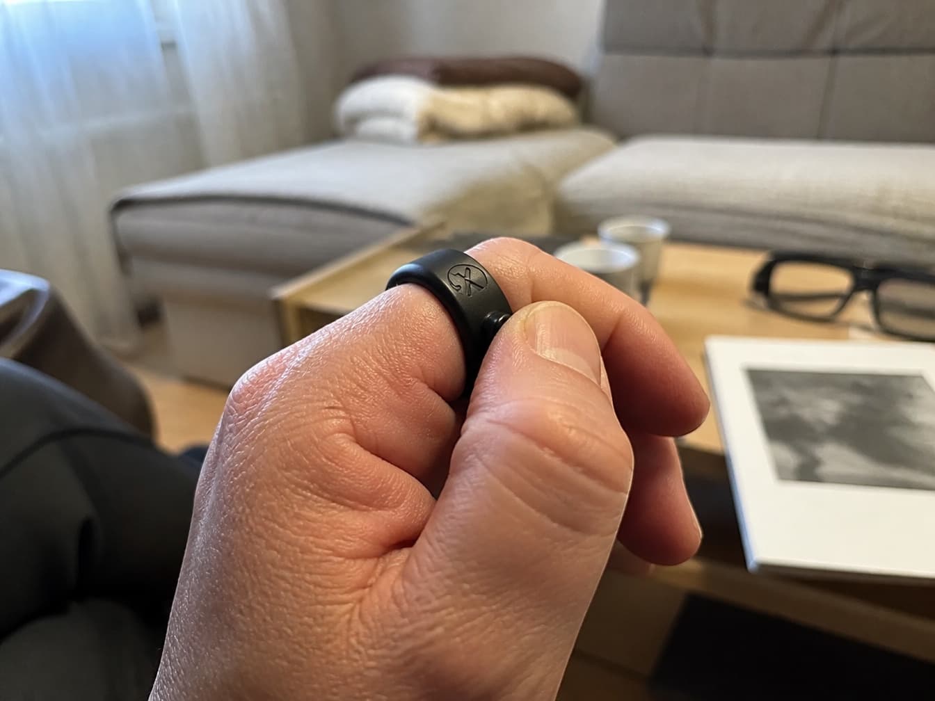 A thumb pressing the Smart Ring controller worn on a finger.